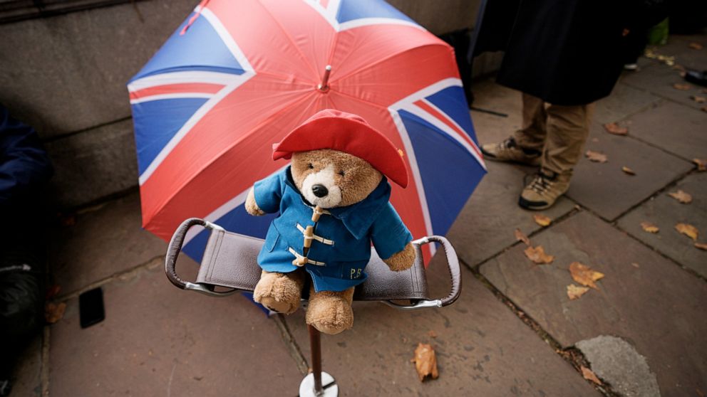 FILE - A Paddington bear stuffed toy is placed on a chair next to a Union flag umbrella as people wait opposite the Palace of Westminster to be first in line bidding farewell to Queen Elizabeth II in London on Sept. 14, 2022. More than 1,000 Paddingt