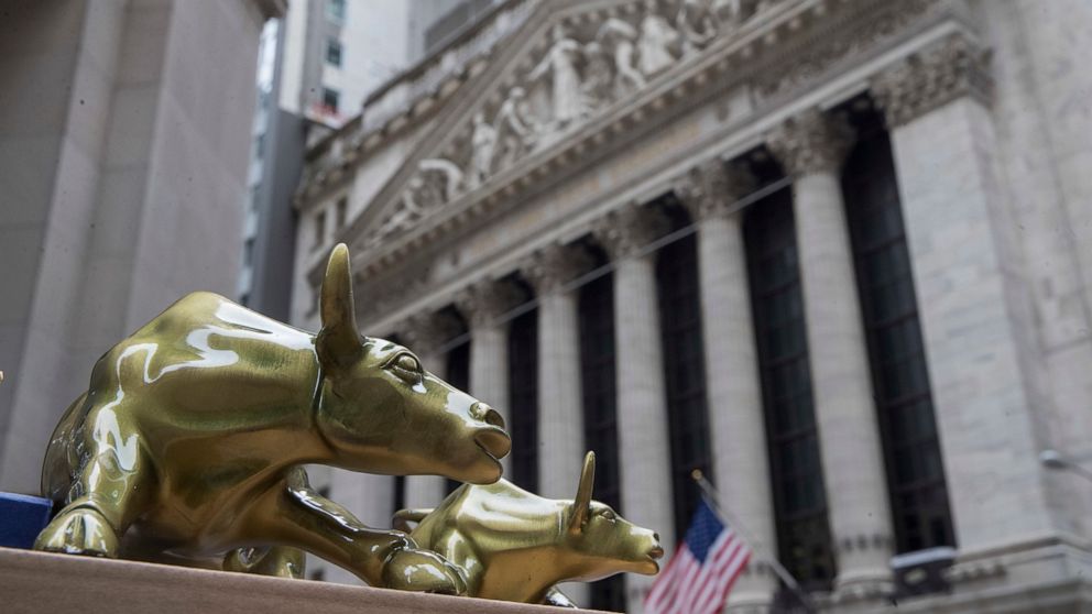 FILE- In this April 24, 2018, file photo replicas of Arturo Di Modica's "Charging Bull" are for sale on a street vendor's table outside the New York Stock Exchange. U.S. stocks moved broadly lower in morning trading Tuesday, Sept. 10, 2019 as investo