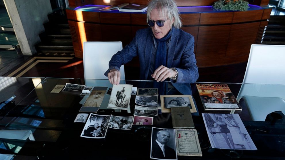 Jed Leiber shows photos of his grandfather Saemy Rosenberg's life at home Thursday, Dec. 3, 2020, in Los Angeles. (AP Photo/Marcio Jose Sanchez)