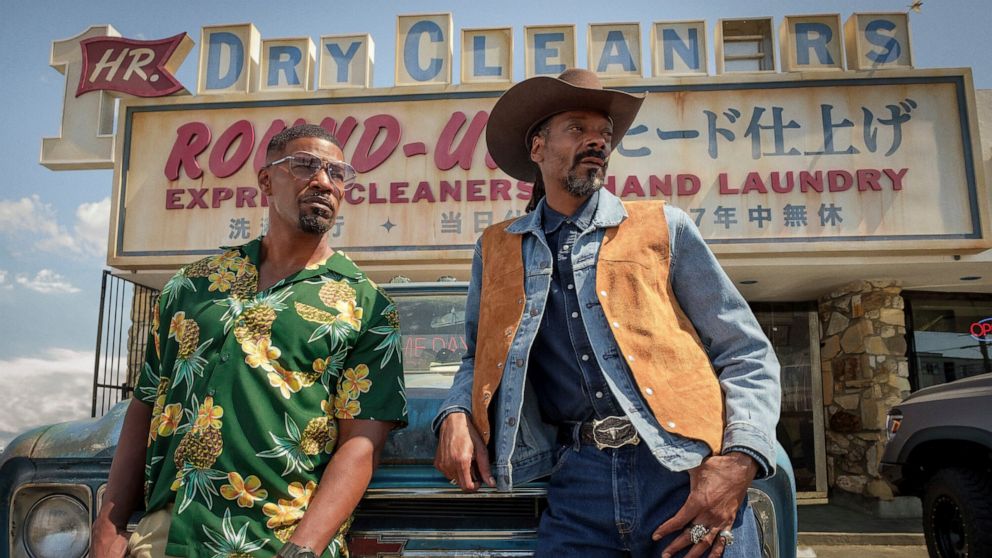 This image released by Netflix shows Jamie Foxx, left, and Snoop Dogg in a scene from 