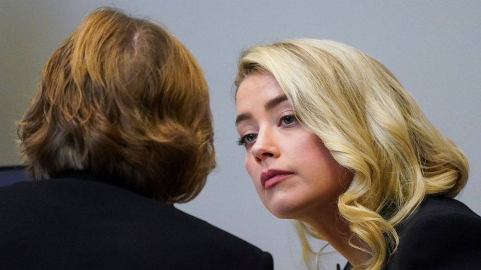 Actor Amber Heard talks with her lawyer Elaine Bredehoft in the courtroom at the Fairfax County Circuit Courthouse in Fairfax, Va., Wednesday, May 18, 2022. Actor Johnny Depp sued his ex-wife Amber Heard for libel in Fairfax County Circuit Court afte
