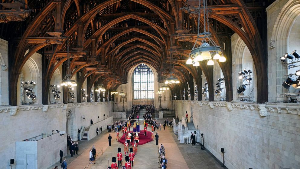 Members of the public pay their respects as they walk past the coffin of Queen Elizabeth II, draped in the Royal Standard with the Imperial State Crown and the Sovereign's orb and sceptre, lying in state on the catafalque in Westminster Hall, London,