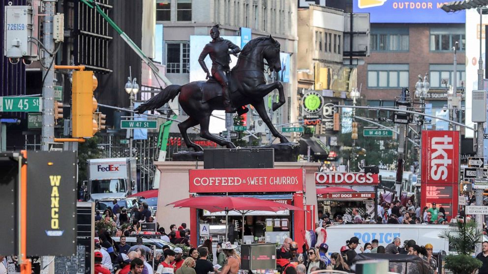 FILE - In this Sept. 27, 2019 file photo, a bronze sculpture, "Rumors of War," by artist Kehinde Wiley, appears in Times Square in New York. Wiley’s monumental bronze sculpture of a young black man astride a galloping horse is set to be permanently i