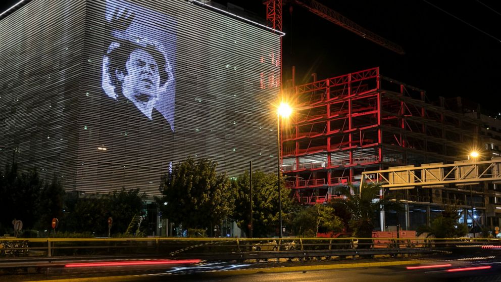 A photograph of late Greek composer Mikis Theodorakis is projected at the facade of Onassis Stegi cultural centre, in Athens, Greece, Friday, Sept. 3, 2021. Mikis Theodorakis, the beloved Greek composer whose rousing music and life of political defia