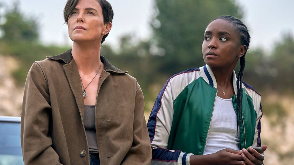 This image released by Netflix shows Charlize Theron, left, and Kiki Layne in a scene from "The Old Guard," premiering July 10 on Netflix. (Aimee Spinks/Netflix via AP)