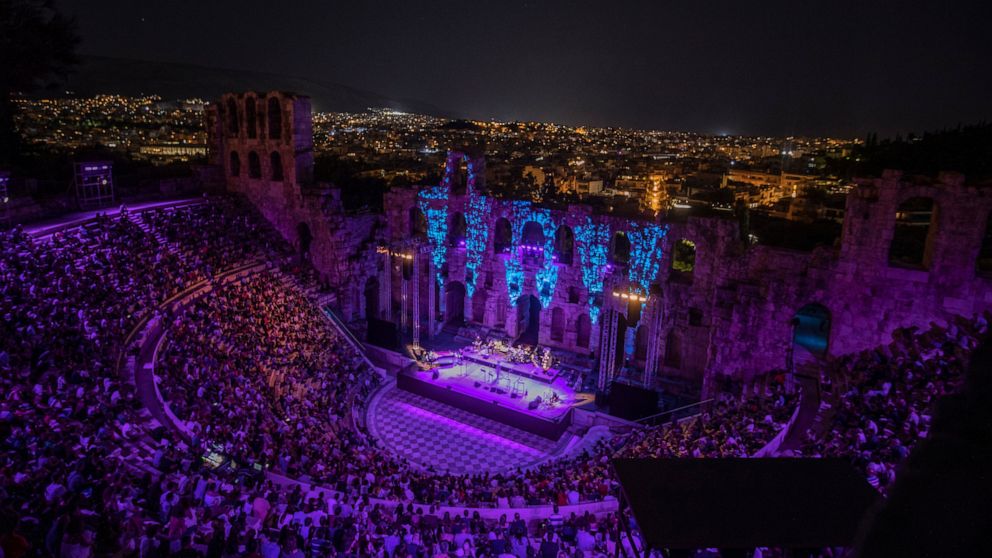 Spectators listen a concert at Odeon of Herodes Atticus as the city of Athens is seen on the background on Wednesday, July 15, 2020. The ancient theaters of Herodes Atticus in Athens and Epidaurus in the southern Peloponnese area have reopened for pe
