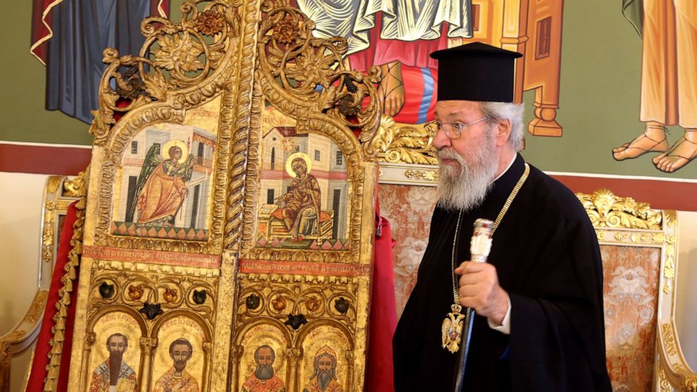 The leader of Cyprus Orthodox Church, Archbishop Chrysostomos II stands next to a pair of ornate, gilded doors that guard the altar of a church, at the Archbishopric in the capital Nicosia, on Thursday, Sept. 16, 2021 . The 18th century doors that we