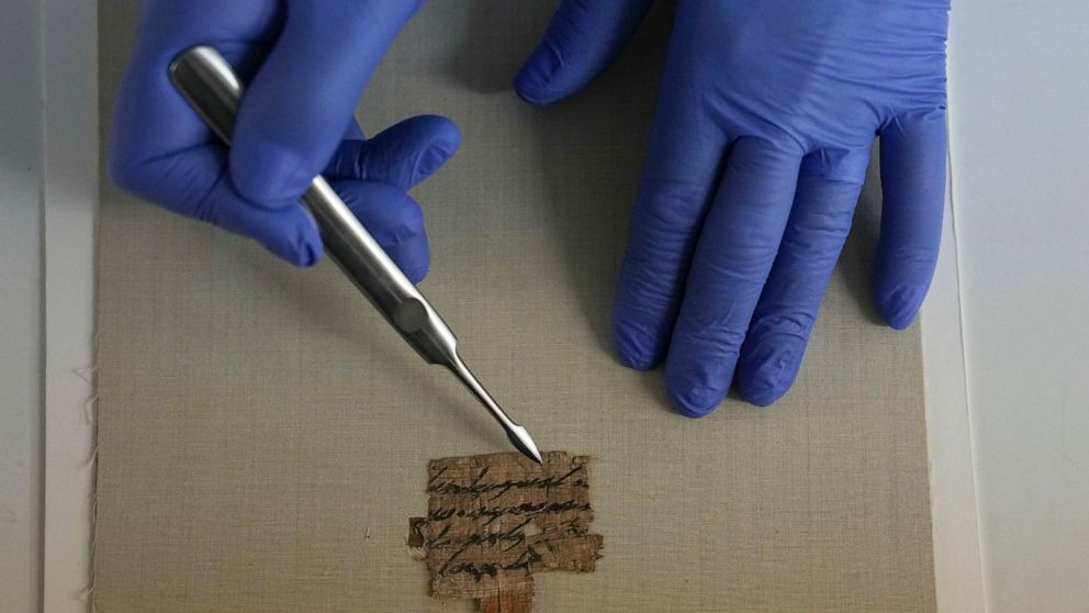 Israeli Antiquities Authority's official conservator, Tanya Bitler, shows a papyrus fragment at their lab inside the Israel Museum in Jerusalem, Wednesday, Sept. 7, 2022. The Israel Antiquities Authority, IAA, said Wednesday that it had obtained the 