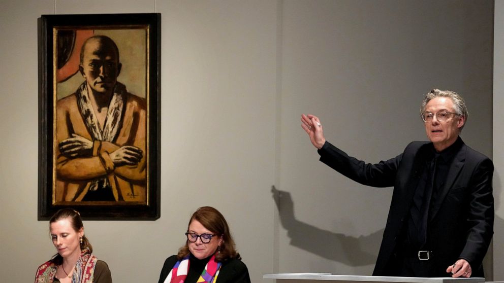 Auctioneer Markus Krause gestures in front of the painting 'Selbstbildnis gelb-rosa' (self-portrait yellow-rose), 1943 oil on canvas, by German painter Max Beckmann, as it is auctioned in Berlin, Germany, Thursday, Dec. 1, 2022. A self-portrait paint