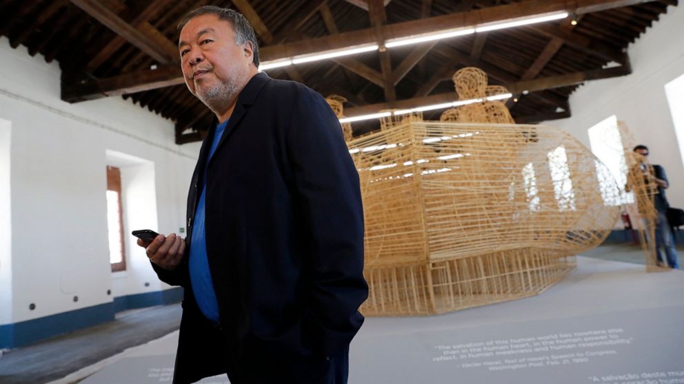 Dissident Chinese artist Ai Weiwei walks by his work "Life Cycle", a migrants' boat made of bamboo, during a press preview of his new exhibition "Rapture" in Lisbon, Thursday, June 3, 2021. The world-renowned artist is putting on the biggest show of 