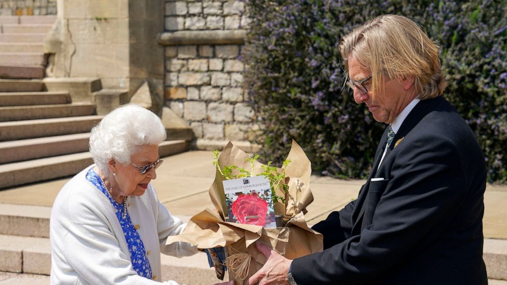 Britain's Queen Elizabeth II receives a Duke of Edinburgh rose, given to her by Keith Weed, President of the Royal Horticultural Society, at Windsor Castle, England, Wednesday June 9, 2021. The newly bred deep pink commemorative rose has officially b