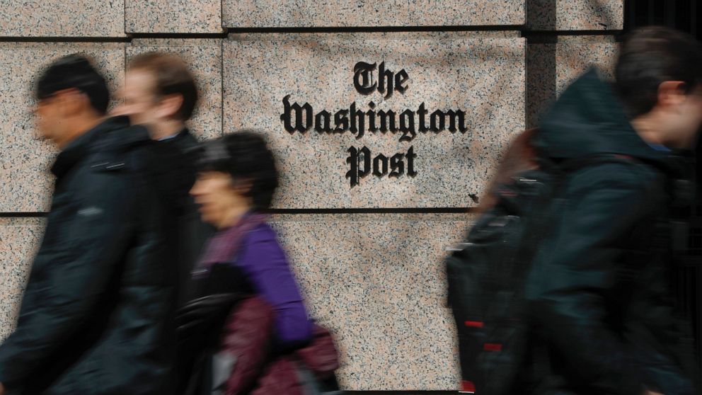 FILE - People walk by the One Franklin Square Building, home of The Washington Post newspaper, in downtown Washington on Feb. 21, 2019. The Washington Post has fired reporter Felicia Sonmez, who has triggered a vigorous online debate this past week o