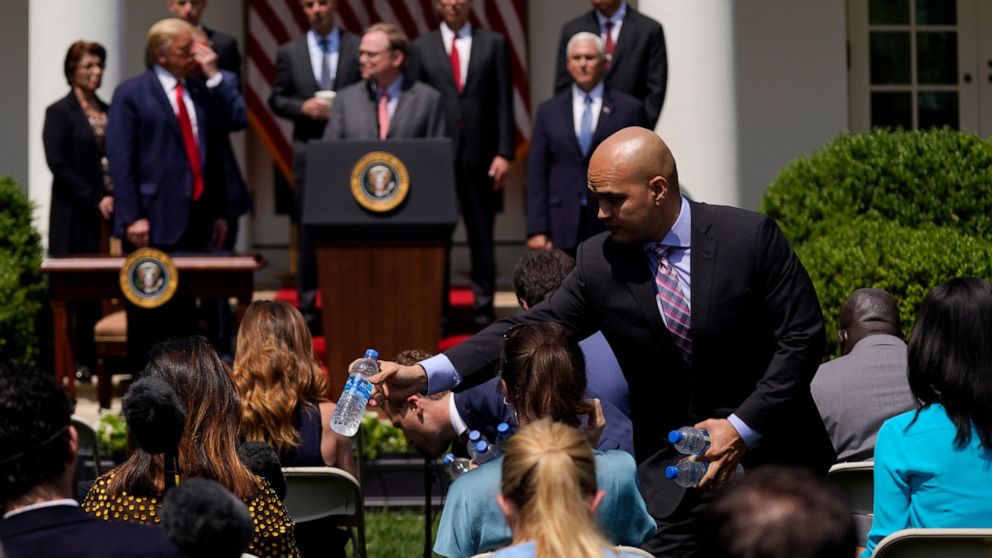 Water is handed out to members of the press as President Donald Trump holds a news conference in the Rose Garden of the White House, Friday, June 5, 2020, in Washington. (AP Photo/Evan Vucci)