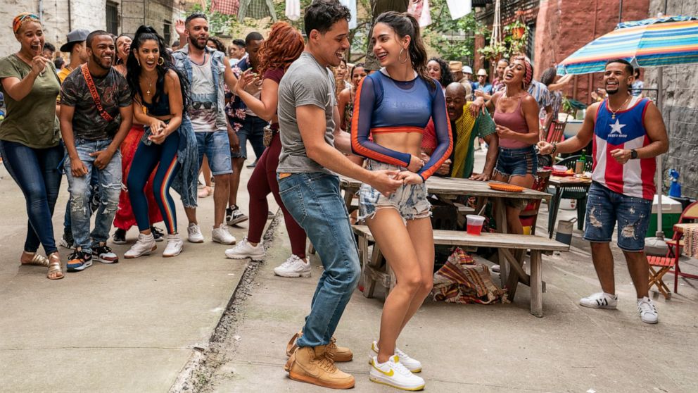 This image released by Warner Bros. Picures shows Anthony Ramos, foreground left, and Melissa Barrera in a scene from "In the Heights." (Macall Polay/Warner Bros. Entertainment via AP)