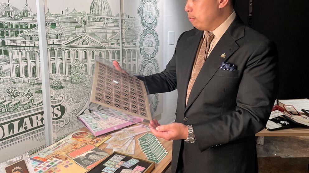 Museum owner Bryan Ong looks at old postage stamps from British Hong Kong, at the private museum The Museum Victoria City, that showcases royal items like postcards, commemorative coins, old banknotes, old postage stamps and various memorabilia in Ho