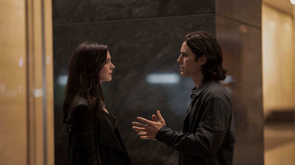 This image released by Apple TV+ shows Anne Hathaway, left, and Jared Leto in a scene from the limited series "WeCrashed," about the rise and fall of WeWork. (Peter Kramer/Apple TV+ via AP)