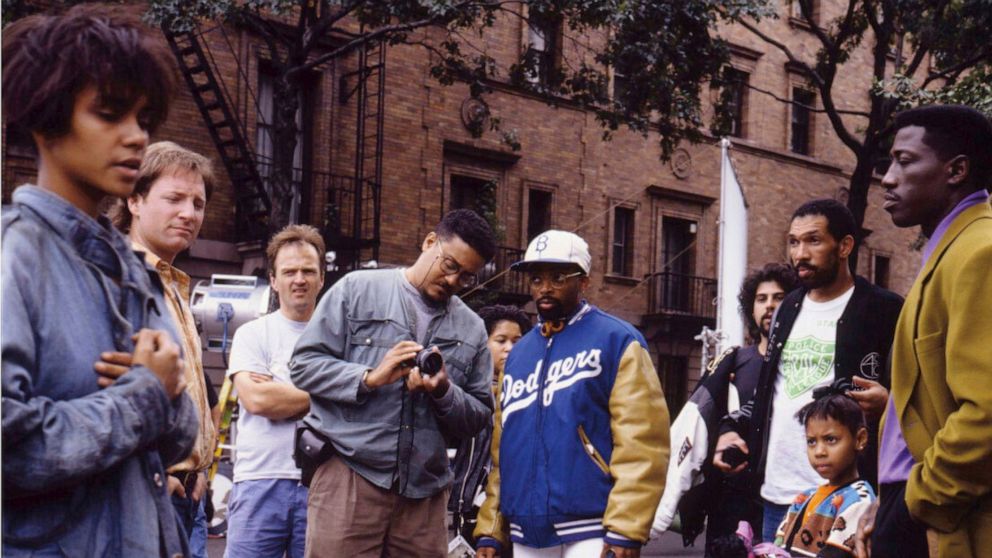 Filmmaker Spike Lee, center right, appears with his brother David Lee, center left, with castmembers, including Halle Berry, left, and Wesley Snipes, right, on the set of the 1991 film, "Jungle Fever." A new photography book spanning Spike's career b