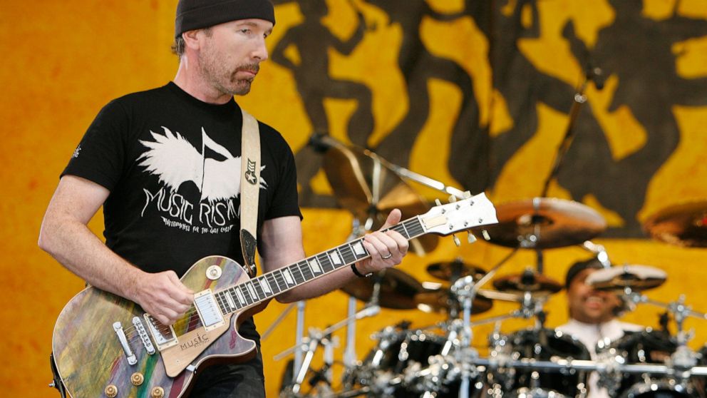 FILE - U2 guitarist The Edge wears a Music First T-shirt as he performs during the New Orleans Jazz and Heritage Festival in New Orleans on April 29, 2006. The Edge and his Music Rising charity will host an auction of rock memorabilia on Dec. 11, 202