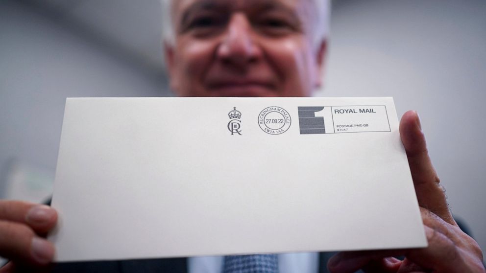 David White, Garter King of Arms, holds one of the first letters to be franked with the new cypher of Britain's King Charles III in the Court Post Office at Buckingham Palace, London, Tuesday Sept. 27, 2022. Along with the Royal Household mail the cy