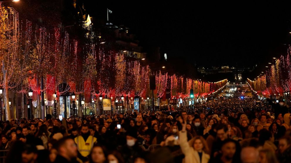 FILE - Spectators gather to attend the Champs Elysee Avenue illumination ceremony for the Christmas season, in Paris, Sunday, Nov. 21, 2021. The committee governing Paris' Champs-Elysees says Tuesday Sept.20, 2022 they are switching off the lights on