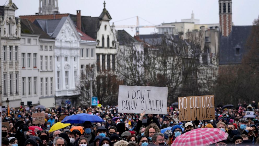 A man holds a sign which reads 'I don't drink Gluhwein' as he protests with other artists during a demonstration in Brussels on Sunday, Dec. 26, 2021. Belgian performers, cinema operators, event organizers and others joined together Sunday to protest