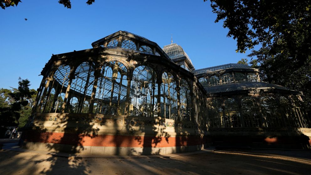 The Glass Palace stands shaded by trees in the Retiro park in Madrid, Spain, Thursday, July 22, 2021. Madrid's tree-lined Paseo del Prado boulevard and the adjoining Retiro park have been added to UNESCO's World Heritage list. The UNESCO World Herita