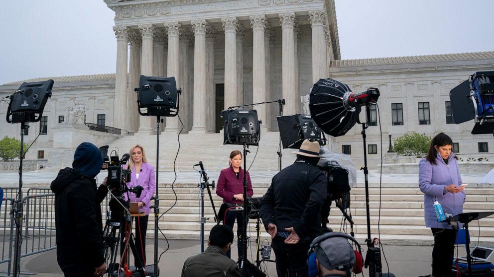 Television news crews stand at the Supreme Court, Tuesday, May 3, 2022, in Washington, following news report by Politico that a draft opinion suggests the justices could be poised to overturn the landmark 1973 Roe v. Wade case that legalized abortion