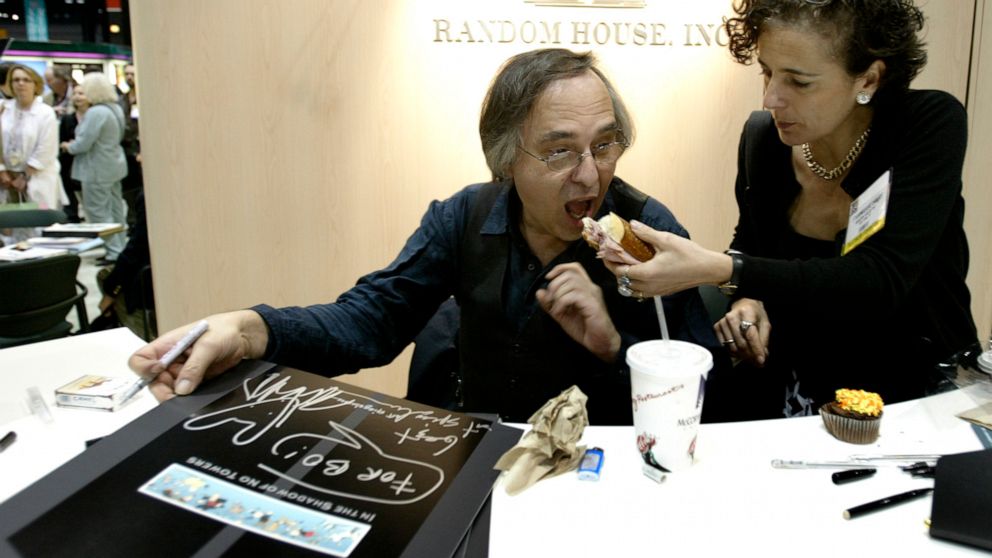 FILE - Artist and author Art Spiegelman gets some help with his lunch from Francoise Mouly, of Random House, Inc., during a signing of Spiegelman's new book "In the Shadow of No Towers" at the Book Expo America convention, Saturday, June 5, 2004, in 