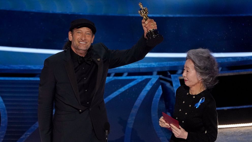 Youn Yuh-jung, right, presents Troy Kotsur with the award for best performance by an actor in a supporting role for "CODA" at the Oscars on Sunday, March 27, 2022, at the Dolby Theatre in Los Angeles. (AP Photo/Chris Pizzello)