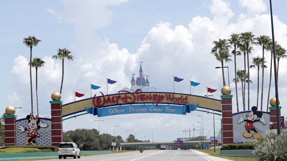 FILE - In this Thursday, July 2, 2020, file photo, cars drive under a sign greeting visitors near the entrance to Walt Disney World, in Lake Buena Vista, Fla. A new television show about the residents and caretakers at Walt Disney World's Animal King