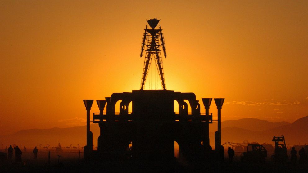 FILE - In this Sept. 2, 2006 file photo, "The Man," a stick figured symbol of the Burning Man art festival, is silhouetted against a morning sunrise in Nevada's Black Rock Desert. The U.S. Bureau of Land Management is recommending attendance be cappe