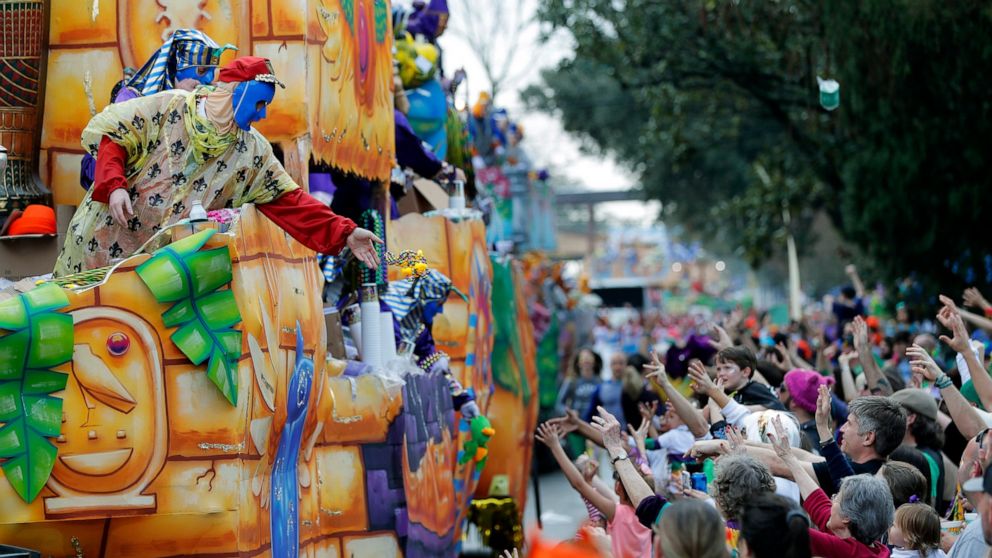 FILE - In this Feb. 11, 2018, file photo, float riders toss beads and trinkets during the Krewe of Thoth Mardi Gras parade in New Orleans. There won’t be any parades on Mardi Gras or during the weeks leading up to it because they just can't fit withi