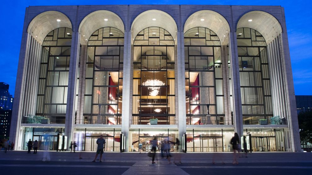 FILE - In this Aug. 1, 2014, file photo, pedestrians make their way in front of the Metropolitan Opera house at New York's Lincoln Center. The Metropolitan Opera has canceled performances and rehearsals through March 31 because of the coronavirus. Th