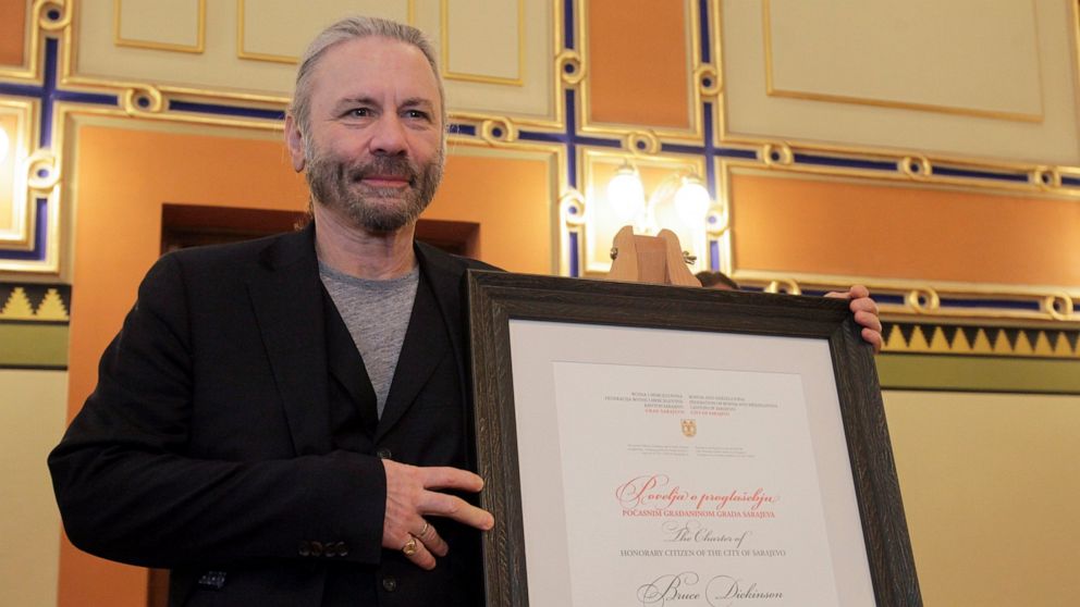 Bruce Dickinson poses for cameras with his honorary citizen certificate at the city hall in Sarajevo, Bosnia-Herzegovina, Saturday, April 6, 2019. Bosnia's capital Sarajevo has declared Iron Maiden lead singer Bruce Dickinson an honorary citizen in g