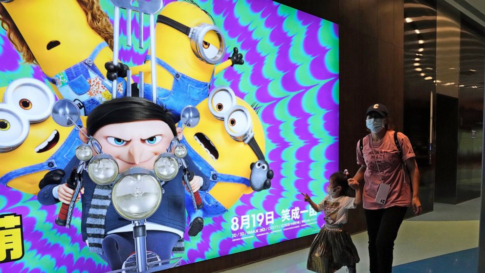 Visitors to a cinema showing the latest "Minions: The Rise of Gru" movie pass by an advertisement for the movie in Beijing, Wednesday, Aug. 24, 2022. The latest “Minions” movie reinforces a message for Chinese audiences that viewers in other countrie