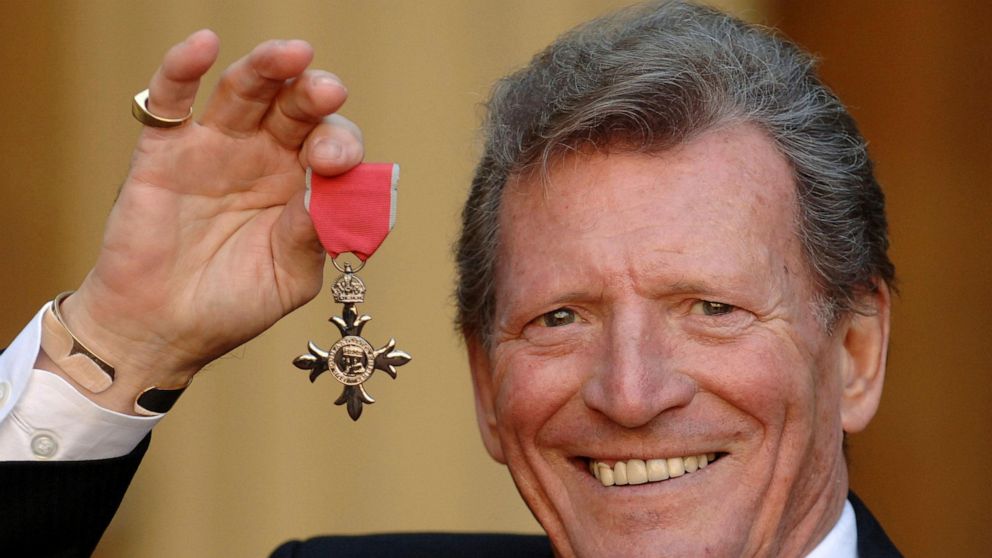 FILE - In this March 7, 2007 file photo, actor Johnny Briggs poses for the media after collecting an MBE from Queen Elizabeth II at Buckingham Palace in London. British actor Johnny Briggs, best known for his role as businessman Mike Baldwin in the l