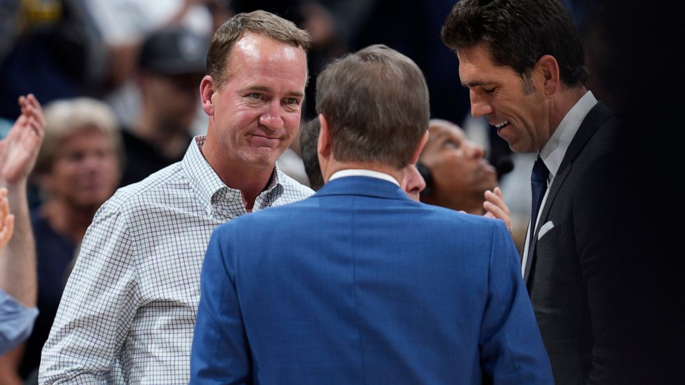Former NFL quarterback Peyton Manning, left, chats with Joe Lacob, majority owner of the Golden State Warriors, during a timeout in the second half of Game 3 of an NBA basketball first-round Western Conference playoff series between the Warriors and 