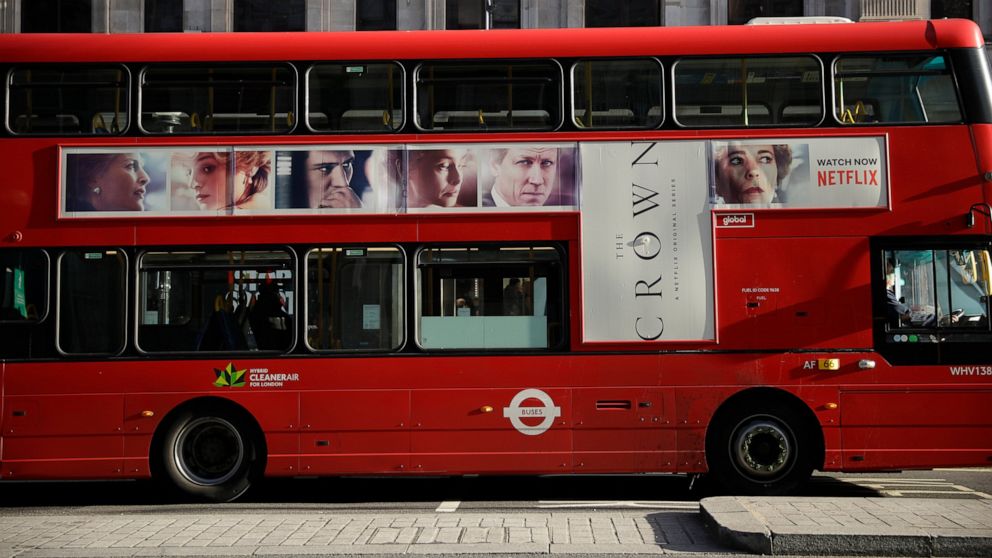 A traditional double decker red bus with an advert for "The Crown" drives through central London, Tuesday, Dec. 1, 2020. Britain's Culture Secretary Oliver Dowden in a newspaper interview published Sunday Nov. 29, 2020, said he thinks "The Crown" sho