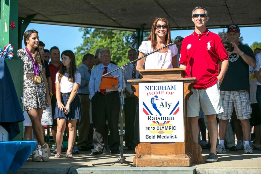 PHOTO: In this file photo, Olympic gold medal gymnast Aly Raisman, front far left, watches as her parents, Lynn Raisman, center, and Rick Raisman, right, thank the crowd as Aly is welcomed home by local residents, Aug. 26, 2012, in Needham, Mass.
