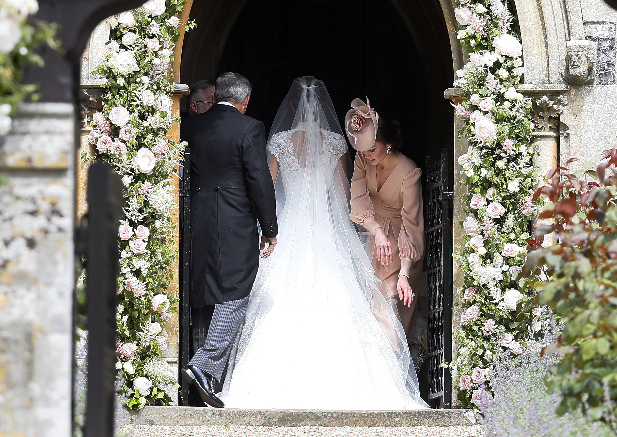 PHOTO: Kate, Duchess of Cambridge, arranges the train of her sister Pippa Middleton as she arrives with her father Michael Middleton for her wedding to James Matthews at St Mark's Church in Englefield, England, May 20, 2017.