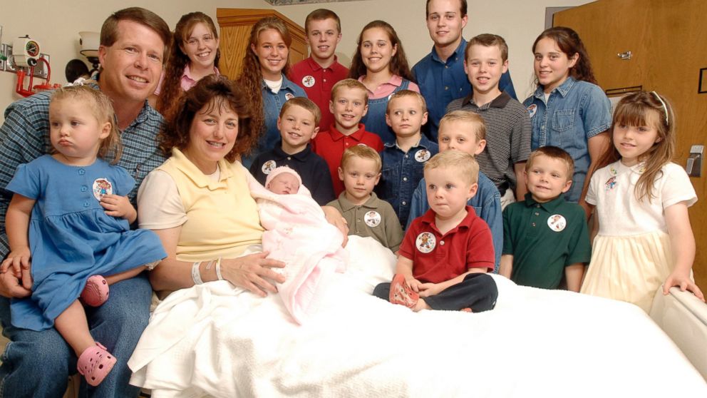 In this Aug. 2, 2007 file photo, Michelle Duggar, left, is surrounded by her children and husband Jim Bob, second from left, after the birth of her 17th child in Rogers, Ark. 