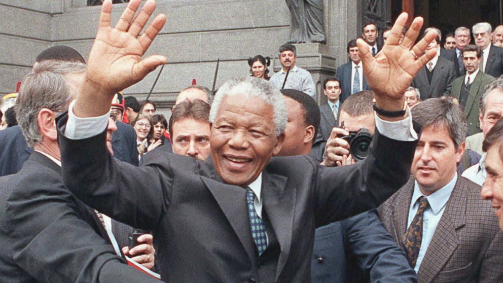 In this July 23, 1998 file photo, South African President Nelson Mandela greets a crowd outside the National Congress building in Buenos Aires, Argentina. 