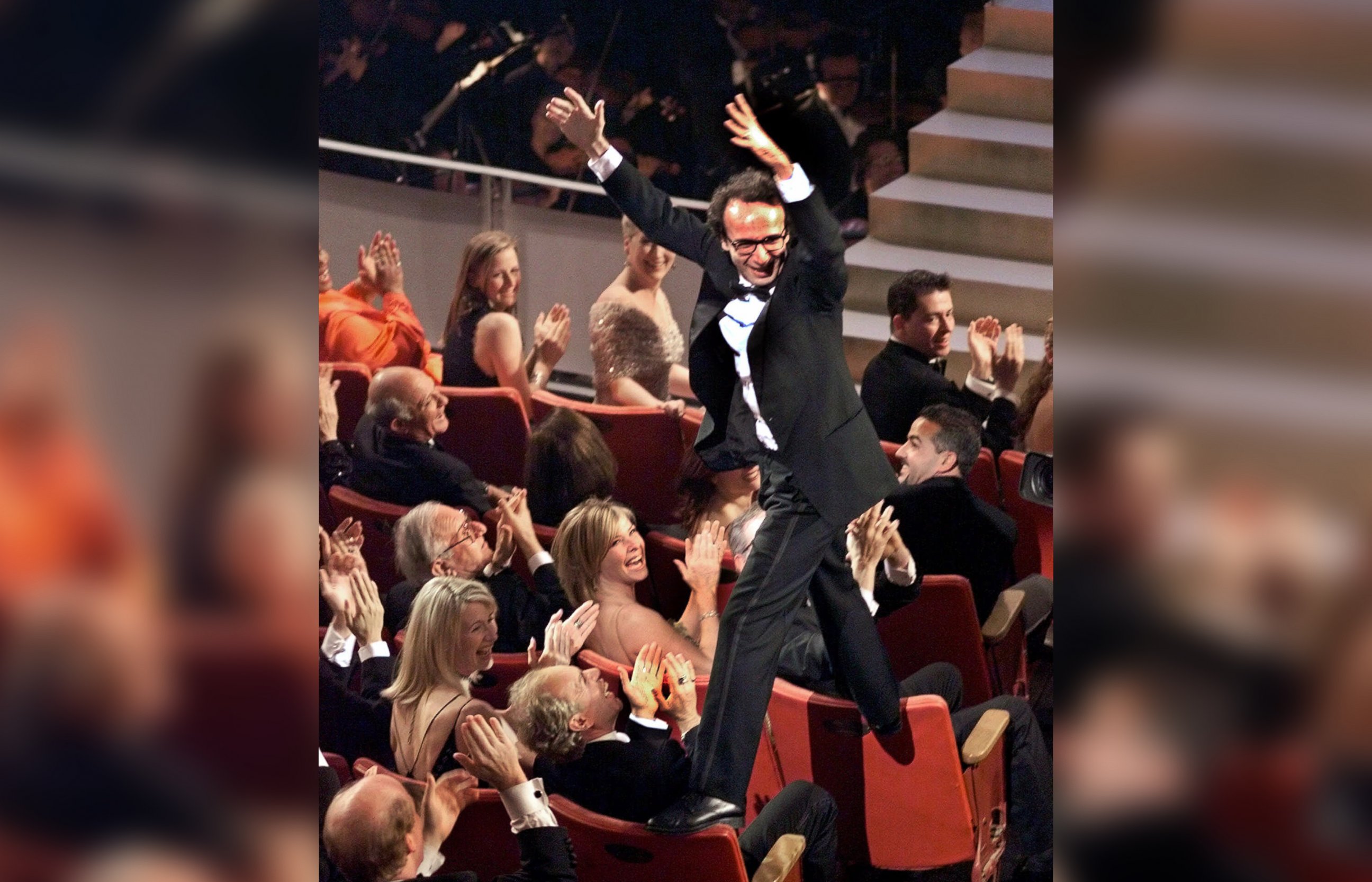 PHOTO: Director and actor Roberto Benigni jumps on the back of some chairs in excitement after winning the Oscar for best foreign language film for "Life is Beautiful," during the 71st Annual Academy Awards on March 21, 1999, in Los Angeles.