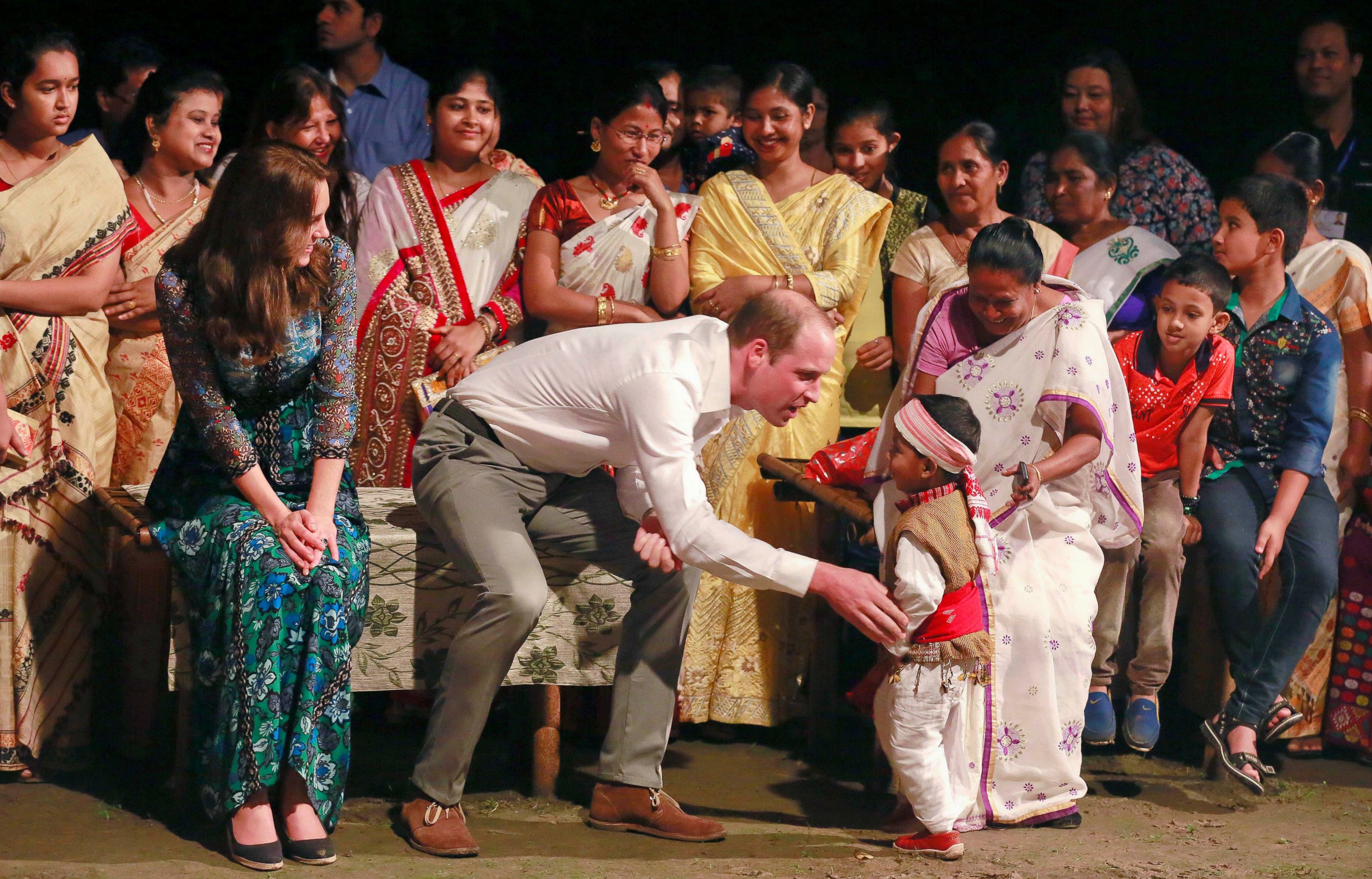 PHOTO: Britain's Prince William and Kate, the Duchess of Cambridge interact with a very young dancer in Diphlu River Lodge in the Kaziranga National Park, northeastern Assam state, India, April 12, 2016.