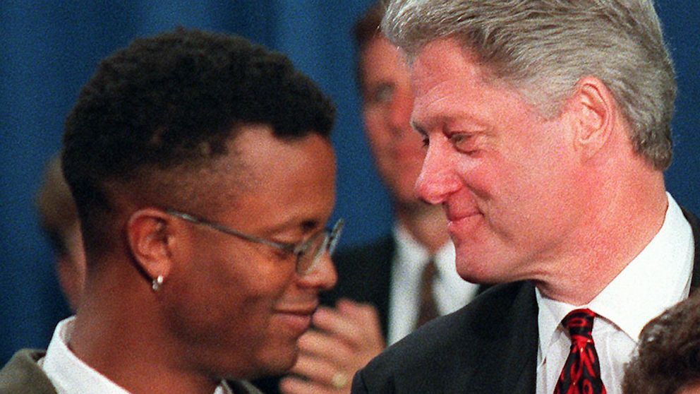 Bill Clinton greets AIDS activist Sean Sasser (L) during the first White House conference on AIDS, Dec. 6, 1995 at the Treasury Department in Washington.
