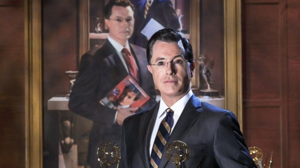 This handout photo provided by the Smithsonian shows Stephen Colbert poising in front of his portrait. Colbert's image is returning to the Smithsonian's National Portrait Gallery. To mark the end of Colbert's nine-year persona on Comedy Central's "The Colbert Report," the museum borrowed Colbert's portrait. The picture was created for the show's final season. Now the new iteration of Colbert's portrait will be installed Friday at the museum. It will be displayed through April 19, once again between the bathrooms and above a water fountain.