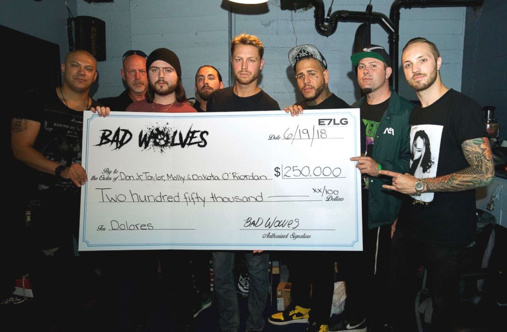PHOTO: Members of the band Bad Wolves, pose for a picture holding a representation of the check that they presented to the family of the late Cranberries singer, Dolores O'Riordan.