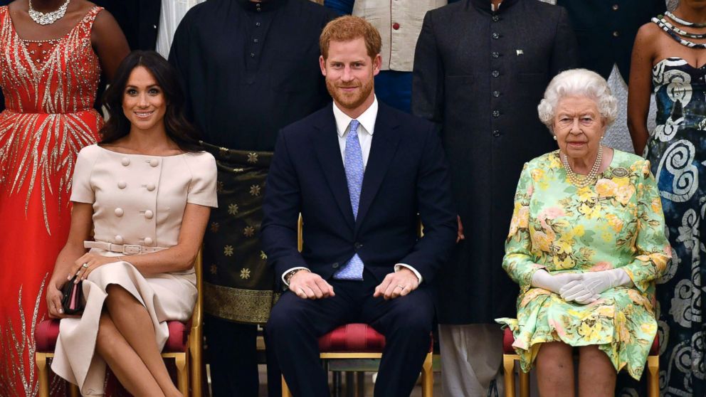 Britain's Queen Elizabeth, Prince Harry and Meghan, Duchess of Sussex pose for a group photo at the Queen's Young Leaders Awards Ceremony at Buckingham Palace in London, June 26, 2018.
