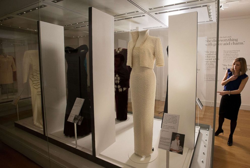 PHOTO: A television reporter gestures as she stands next a dress (R), during a press preview of the forthcoming exhibition entitled "Diana: Her Fashion Story", at Kensington Palace in London, Feb. 22, 2017.