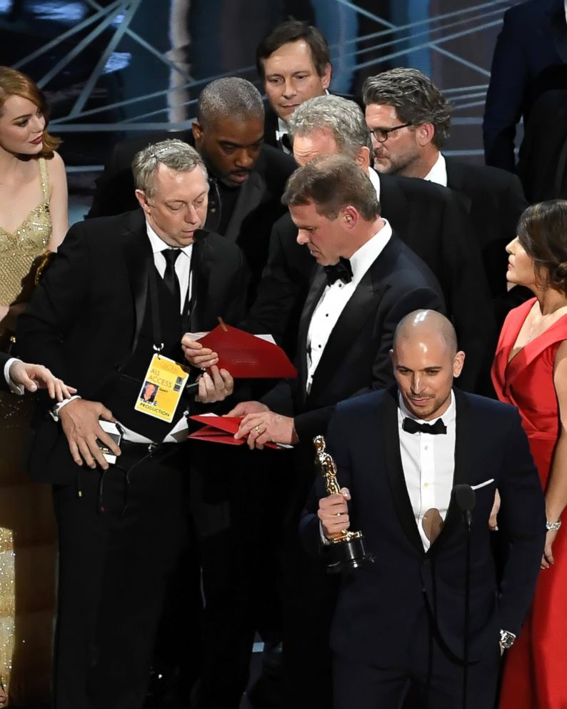 PHOTO: "La La Land" producer Fred Berger, bottom, speaks at the microphone as production staff consult behind him regarding a presentation error of the Best Picture award during the 89th Annual Academy Awards on Feb. 26, 2017 in Los Angeles.
